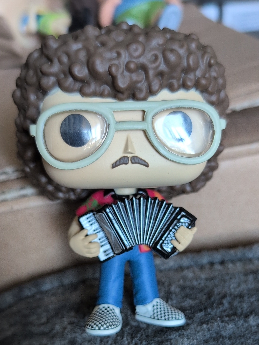 Funko Vinyl Figure with Brown Hair, Blue Pants, Green Glasses, Black Accordion